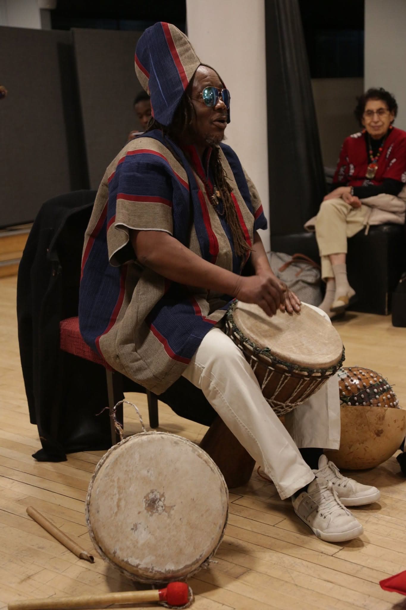 A performer playing a traditional African drum at a cultural event