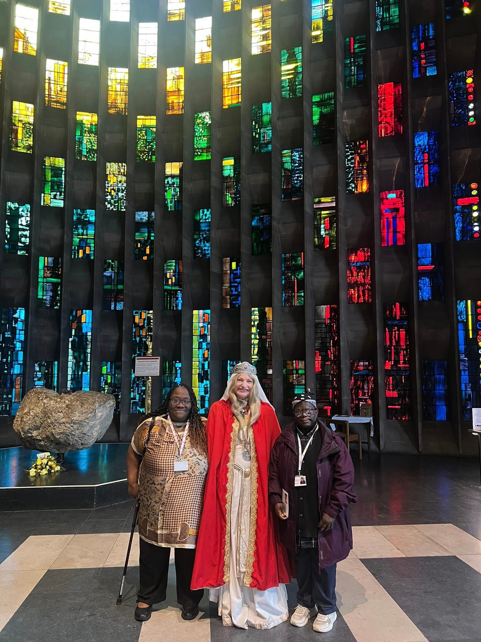 Group photo in front of the stained glass baptistry window at Coventry Cathedral
