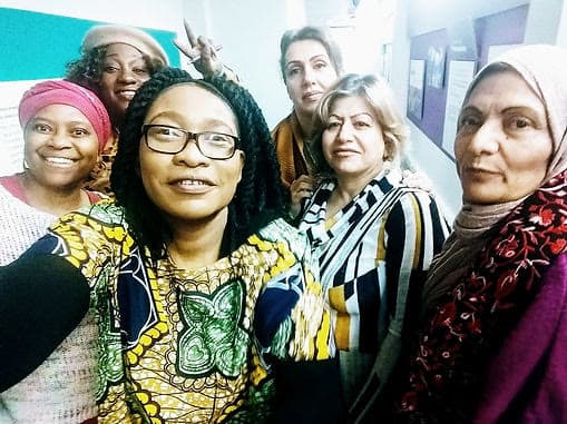 Volunteers smiling together at a community sewing workshop