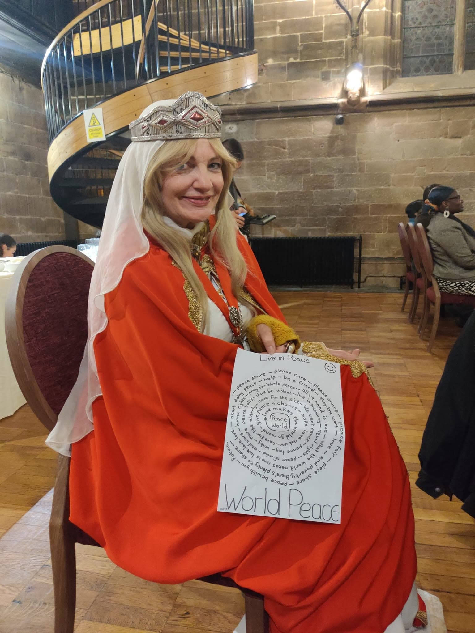 A civic dignitary holding a handwritten message about world peace at the Coventry Peace Festival