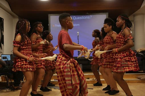 Young performers in matching outfits dancing at a Coventry Diversity Forum cultural programme event